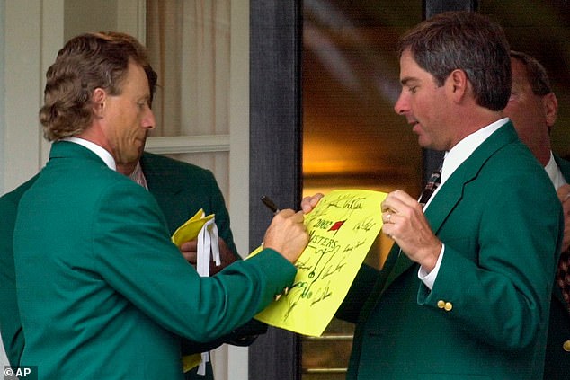 Bernhard Langer signs an autograph for Fred Couples before the 2002 dinner