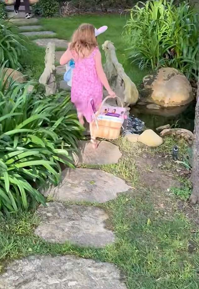 Lilibet was seen walking through the garden wearing bunny ears and carrying a plush rabbit