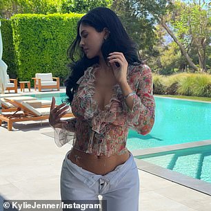 The mother of two was seen raising her arms and tossing her hair to show off her tiny waistline