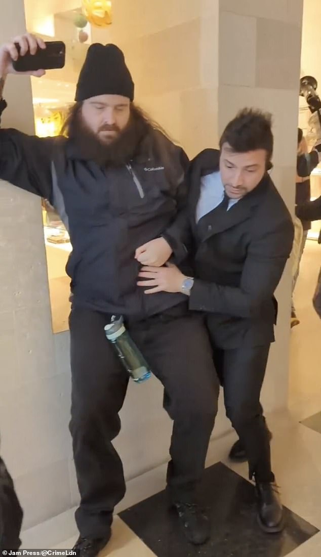 Security guards try to push protesters to the side during the ordeal on Easter weekend