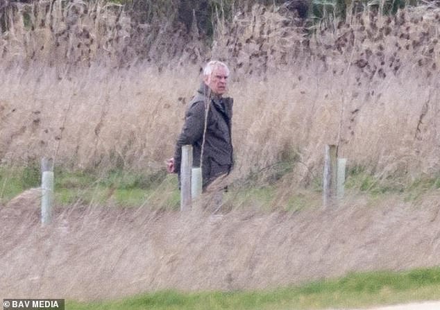 Andrew is pictured walking his dogs on the Sandringham estate on Saturday