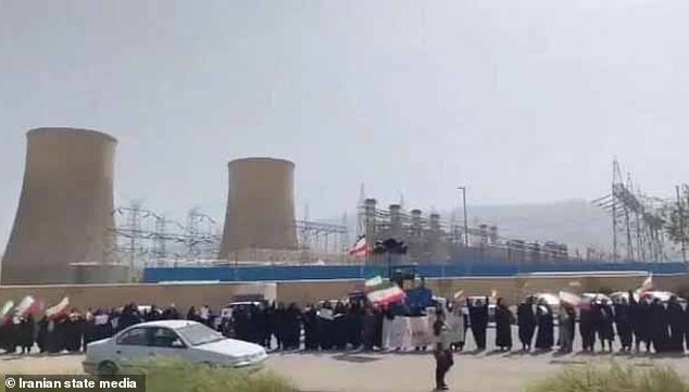 Video on Tuesday showed women and children waving flags as chanting blared on a loudspeaker at a power plant after Trump threatened to bomb infrustructure