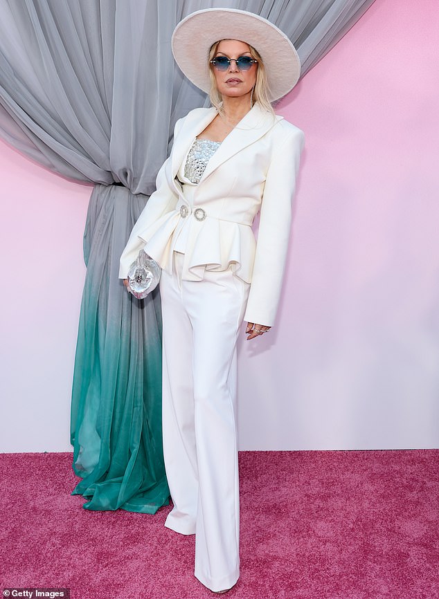 Fergie cut a commanding figure in a white trouser suit jazzed up with flashes of showbiz flair, including gleaming blue cat-eye shades and a wide-brimmed hat