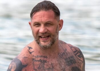 Tom Hardy shows off HUGE tattoo collection as topless star hits the beach with wife Charlotte Riley