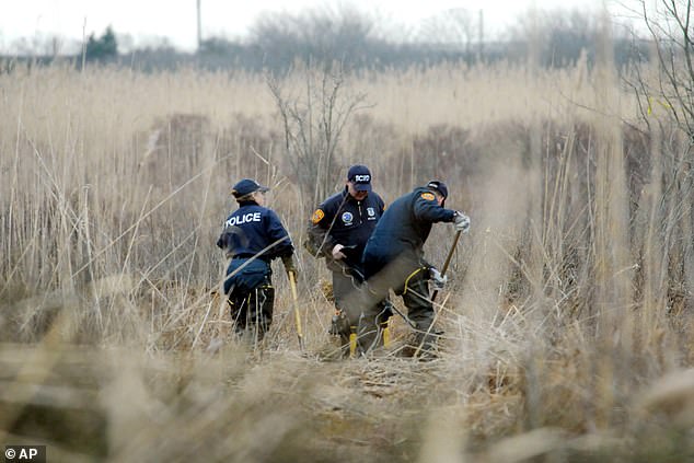 Police search a marsh for the remains of Shannan Gilbert in Oak Beach in December 2011 after the remains of several victims were found in the area