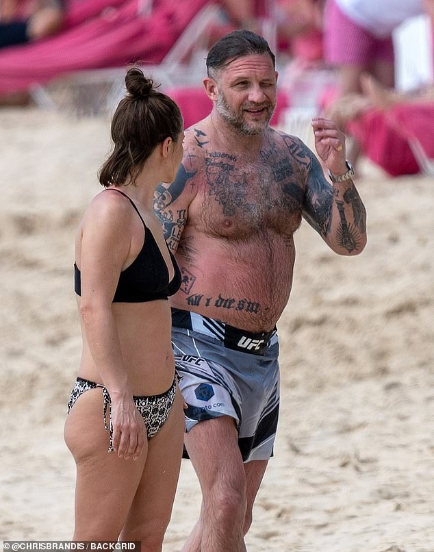 The rugged star was sporting a full beard and pair of black aviator shades during the rare appearance with his bikini-clad wife on the Caribbean island