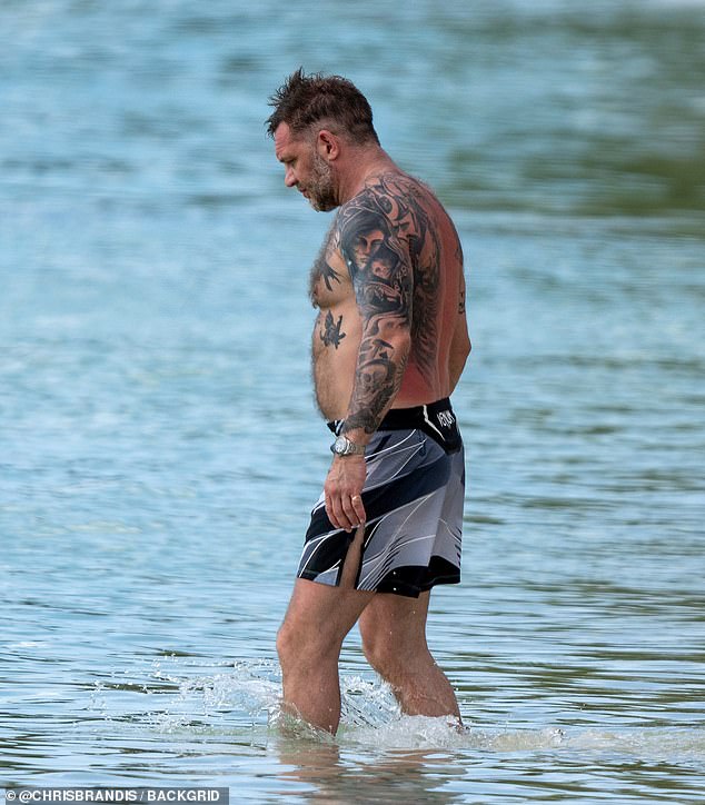 Tom was seen wading into the sea in his Venom shorts