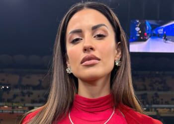 Glamorous TV host and football Wag causes a stir on the sidelines in low-cut top as fans driven wild