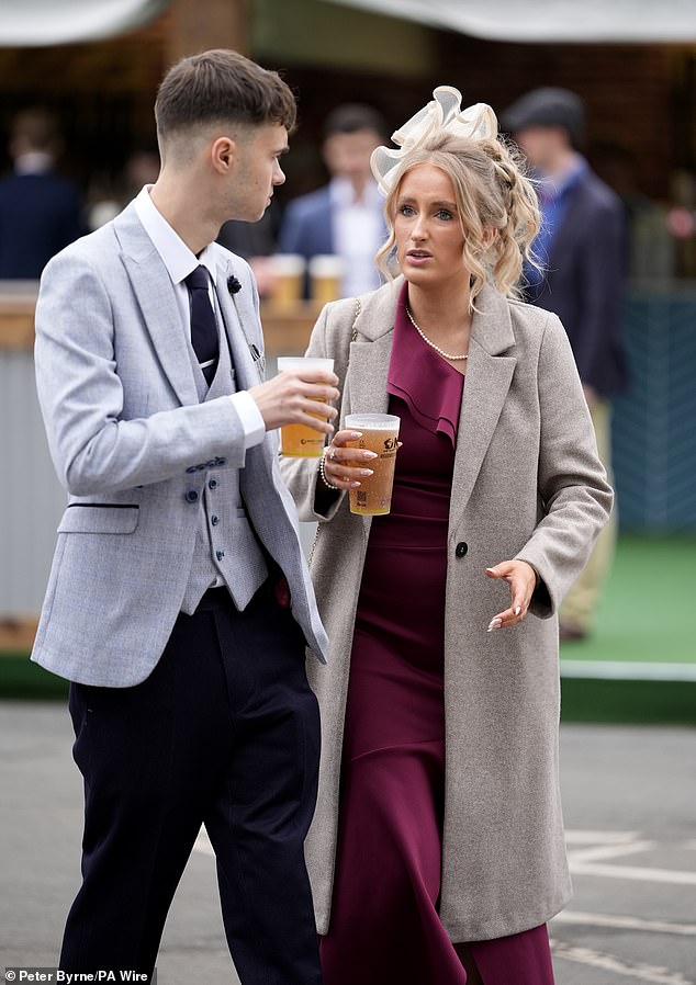 Cheers! Revellers get their pints in before the races start at the first day of the Grand National festival