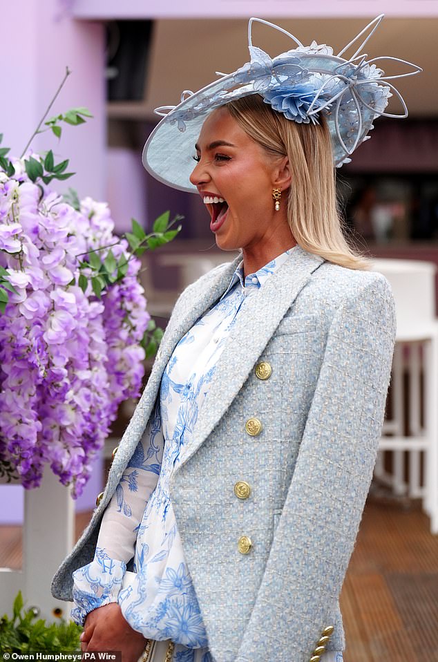 What a laugh! A racegoer shares a giggle as she attends the three-day event in Aintree