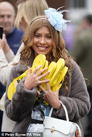 She's prepared for later! A racegoer carries a load of flip-flops on day one of the Randox Grand National Festival