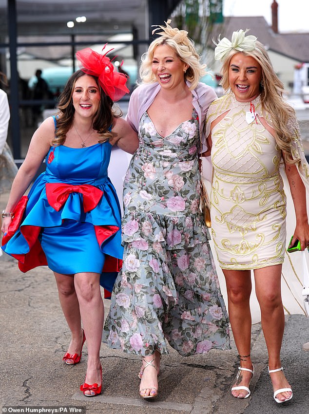 Dressed to impress in daring ensembles and risque mini dresses, racing fans were seen battling with their brollies and huddling together to stay warm as temperatures plummeted 15C from the hottest day of the year on Wednesday