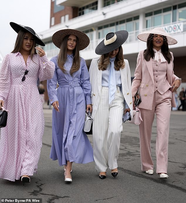 A group of woman pose for the cameras as they arrived for the first day of the Grand National Festival at Aintree