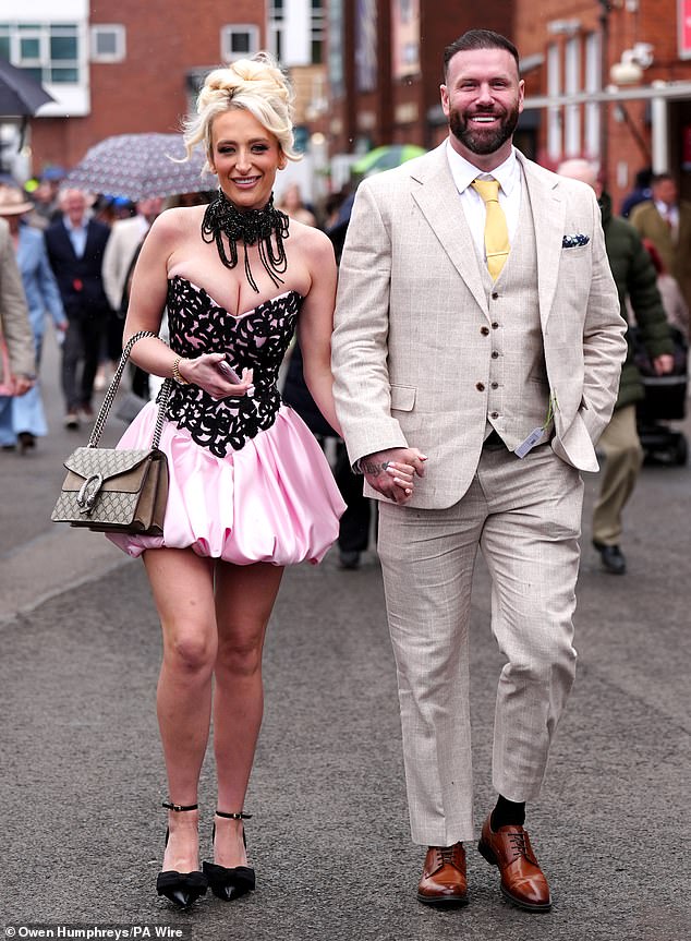 Ready for action! A couple showed off their statement outfits as they arrived at the racecourse yesterday