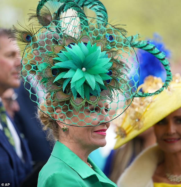 Hat's the spirit! A racegoer showcases her very flamboyant headpiece as she attends the second day of the Grand National festival