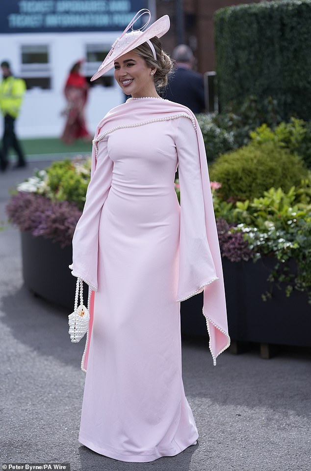 Pretty in pink! A racegoer puts on a classy display in a full-length gown with cape detailing
