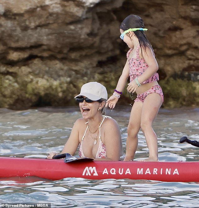 Gigi balanced herself on the paddleboard after joining her mother in the water