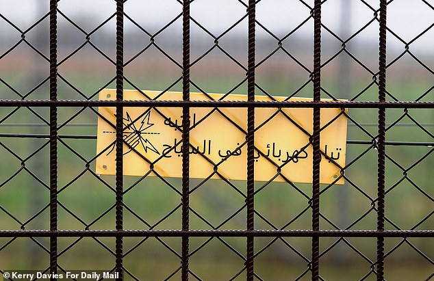 A sign written in Arabic warns migrans of the risks of touching the electrified fence on the Hungarian/Serbian border