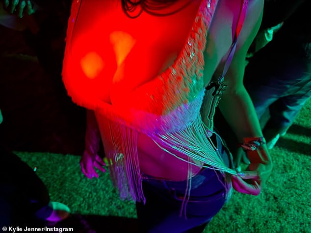 The TV personality put on a busty display wearing a sequin top with tasseled details as well as a pair of low-waisted jeans