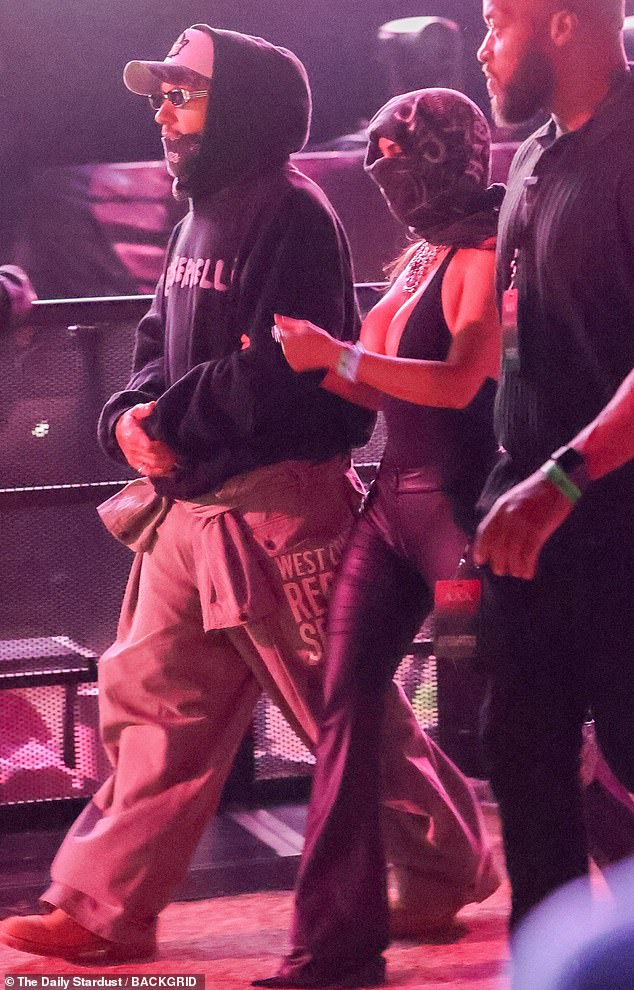 Kardashian was seen linking her arm with Hamilton's as they were guided through a section on the crowded grounds to support Bieber's anticipated performance over the weekend