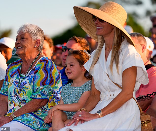 Rory's proud mother smiles as Poppy and Erica, in a wide-brimmed hat, grinned after McIlroy's win