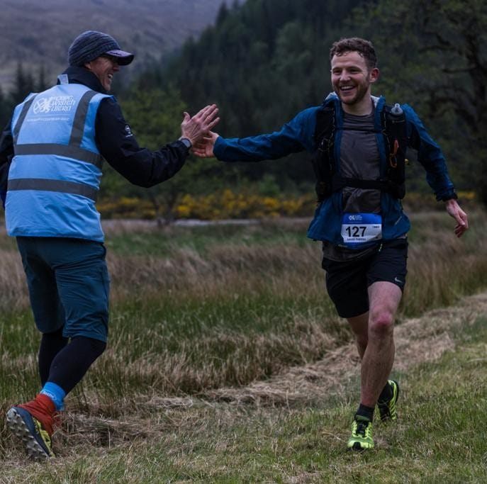 Ultra marathon runner David Parrish high-fives another runner while on the Cape Wrath Trail.