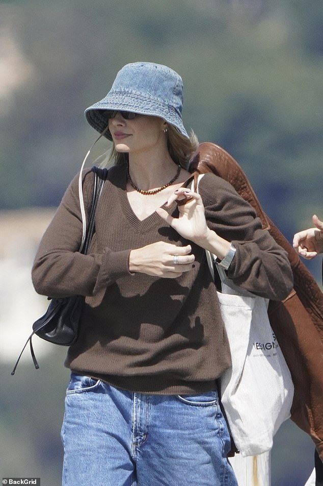 Margot was spotted carried a stylish brown suede jacket and a large white tote bag as she arrived for lunch at the beach bar