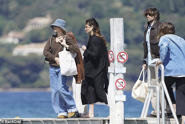 Meanwhile her long-time pal Phoebe wrapped up in a long black coat which she layered over trendy white trousers