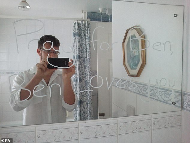 Field is pictured taking a selfie in the reflection of a mirror with the words 'pray for Ben, Ben loves you' written on it