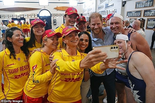 The Duke and Duchess of Sussex pose for a selfie with a surf rescue team