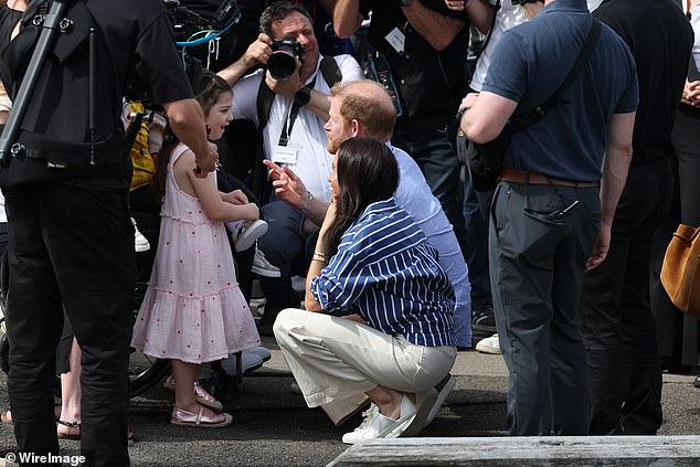 Meghan, Duchess of Sussex and Prince Harry, Duke of Sussex, are presented with some custom thongs by Charlotte Vanderzwan and Invictus Australia
