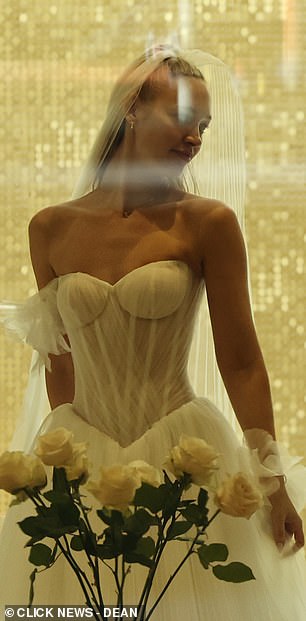 Roxy's blonde locks were swept back into a half-up style to secure her veil