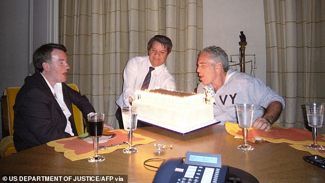 An undated image released by the US Department of Justice shows Mandelson, left, grinning as Epstein, right, blows out the candles on a birthday cake