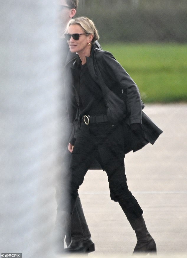 She touched down in the city via helicopter as she strolled across the tarmac in a pair of sunglasses - despite the rain