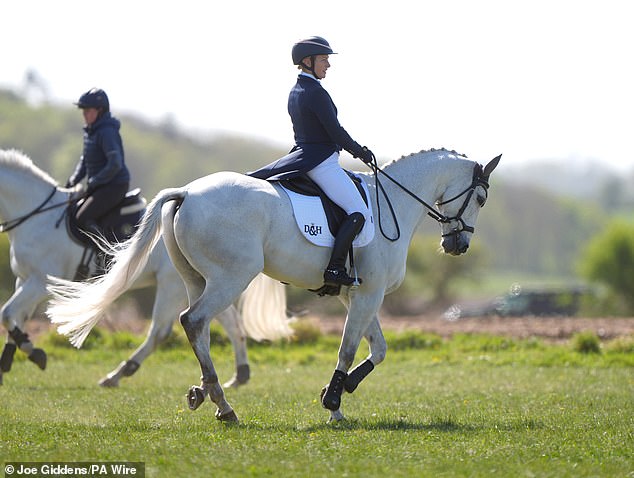 Zara, 44, looked sporty in her navy and white riding uniform, including a helmet and boots