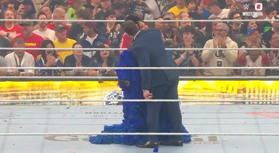 Bianca Belair kisses Montez Ford in the wrestling ring during WrestleMania.