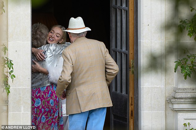 The model, 34, emerged from the 17th-century Euridge Manor in the Cotswolds looking stunning in a feathered white jacket