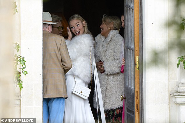 The new bride was still in white, opting for a statement jacket layered over a slinky dress and accessorised with a white Chanel bag for the Sunday festivities
