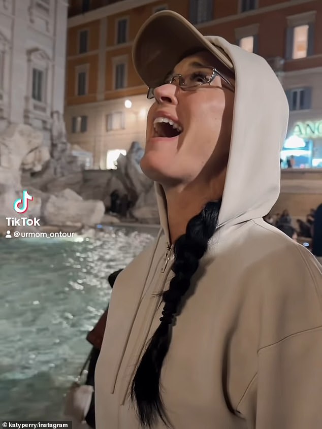 The clip started out with Perry standing in front of the fountain in a grey hoodie and singing 'someone give me a penny'