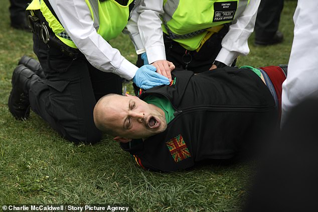 The man appeared to shout as he was restrained by at least four officers