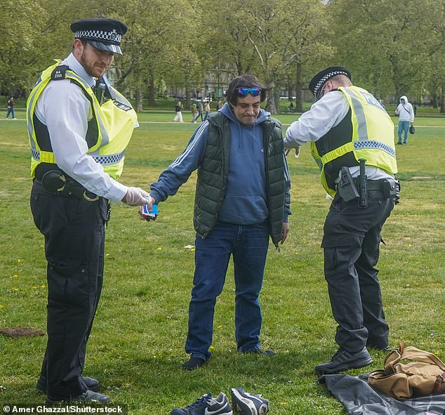 A man wearing no shoes was searched by one officer as anotherstood nearby