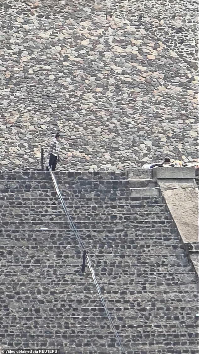 The apparent gunman stands near people lying on the steps of a pyramid during an incident where authorities say a Canadian woman was shot dead and several others injured before the gunman killed himself at the Teotihuacan pyramids, a popular tourist and archaeological site, in San Martin de las Piramides, on the outskirts of Mexico City, Mexico, April 20, 2026