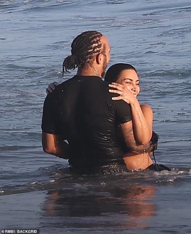 They stood in the shallow end of the ocean as they put their arms around each other