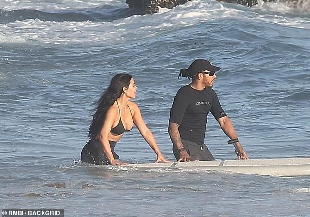 The daughter of Kris Jenner also pushed a paddle board out into the water as Hamilton did the same