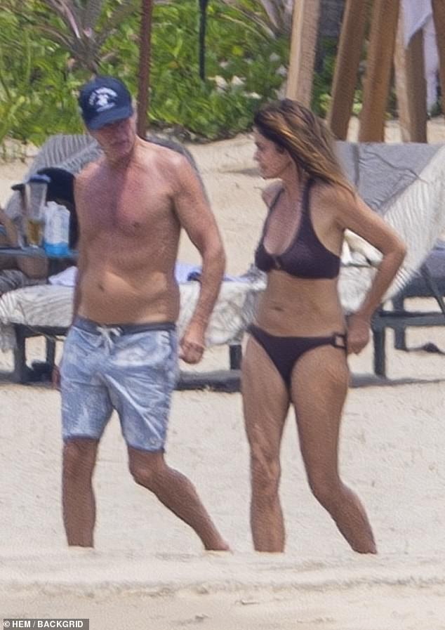 For his part, Gerber walked the beach in blue swim trunks and a navy blue baseball cap
