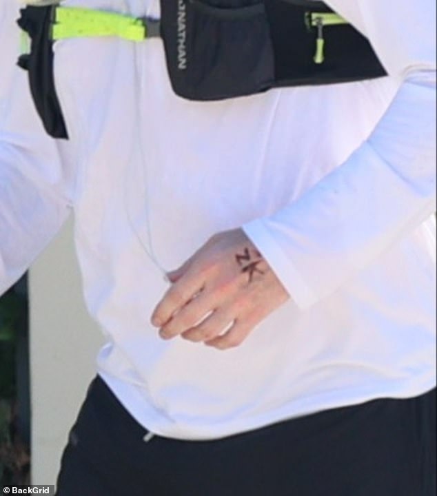 Amid their romance the actor got his fiancée's initials tattooed on the back on his hand  (pictured) and made a rare comments about their relationship