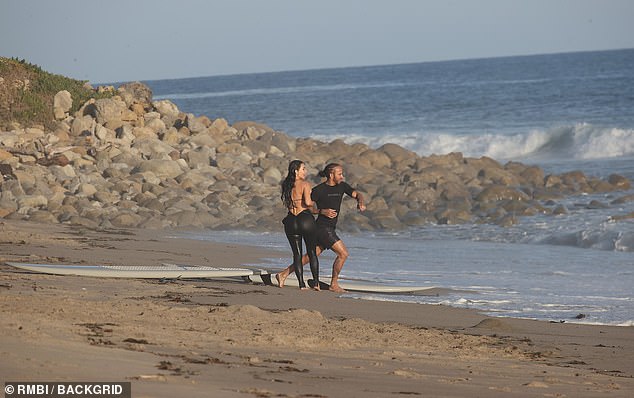 The pair were later seen frolicking on the beach near Kim's Malibu home... in an image also captured by the celebrity photo agency Backgrid