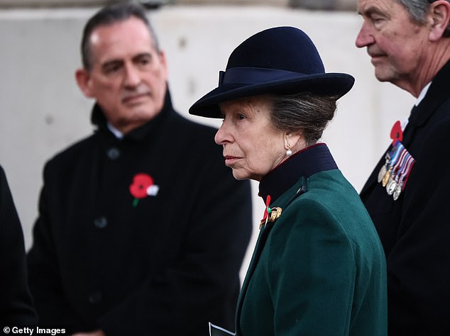 She was dressed in a emerald green tailored coat, complemented by a structured hat and black gloves, while a red poppy adorned her lapel
