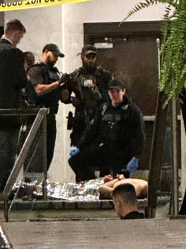 Members of law enforcement respond during the White House Correspondents Dinner. Allen can be seen lying on the ground with their hands behind his back