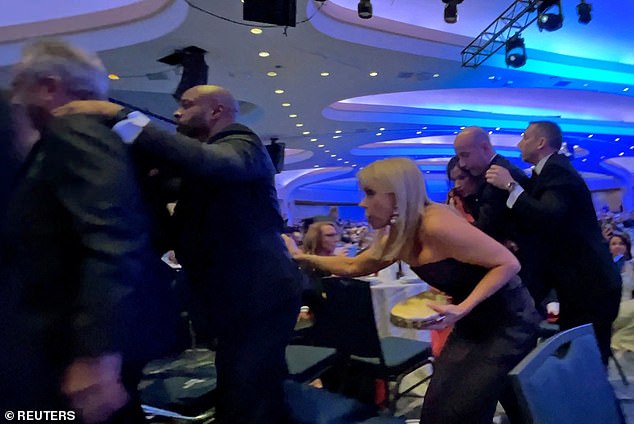 Health Secretary Robert F. Kennedy Jr. and his wife Cheryl Hines, and Deputy Chief of Staff for Policy Stephen Miller and his wife Katie Miller are escorted out of the room by Secret Service
